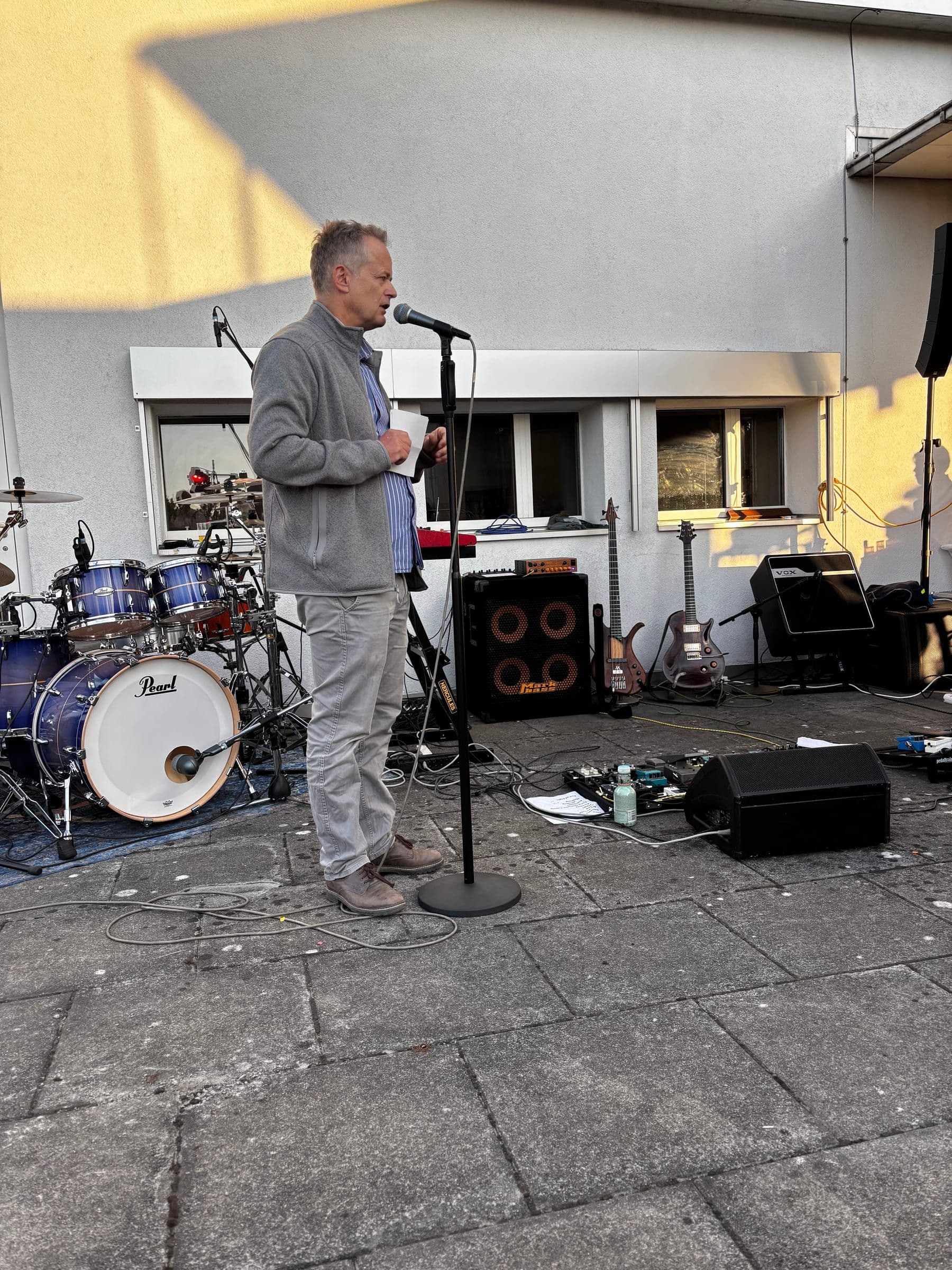 25 Jahre Kampagnenforum: Ansprache am Mikrofon vor dem Schlagzeug