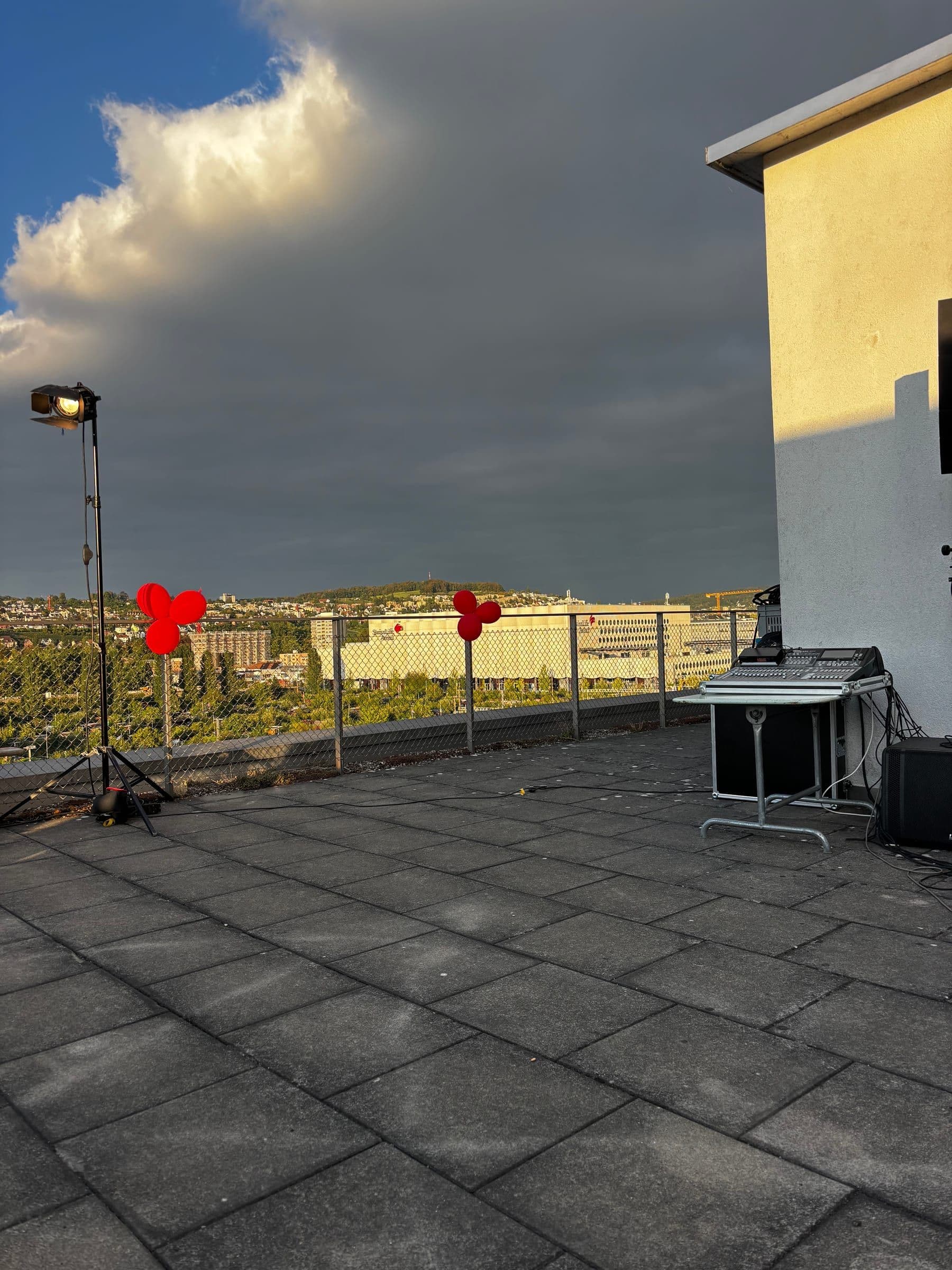 25 Jahre Kampagnenforum: Terrasse mit roten Ballons unter Gewitterwolken